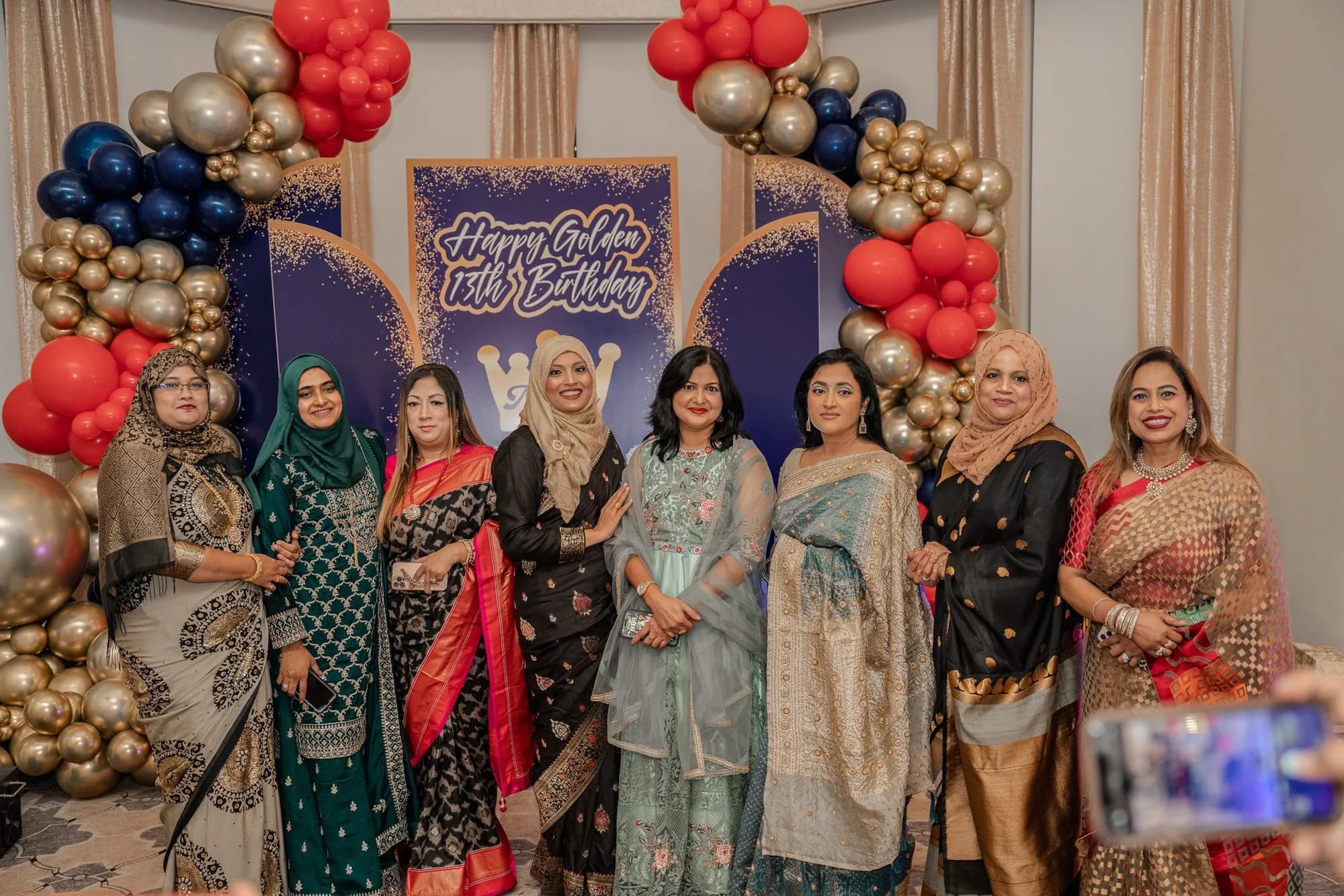 Guests at a birthday balloon arch