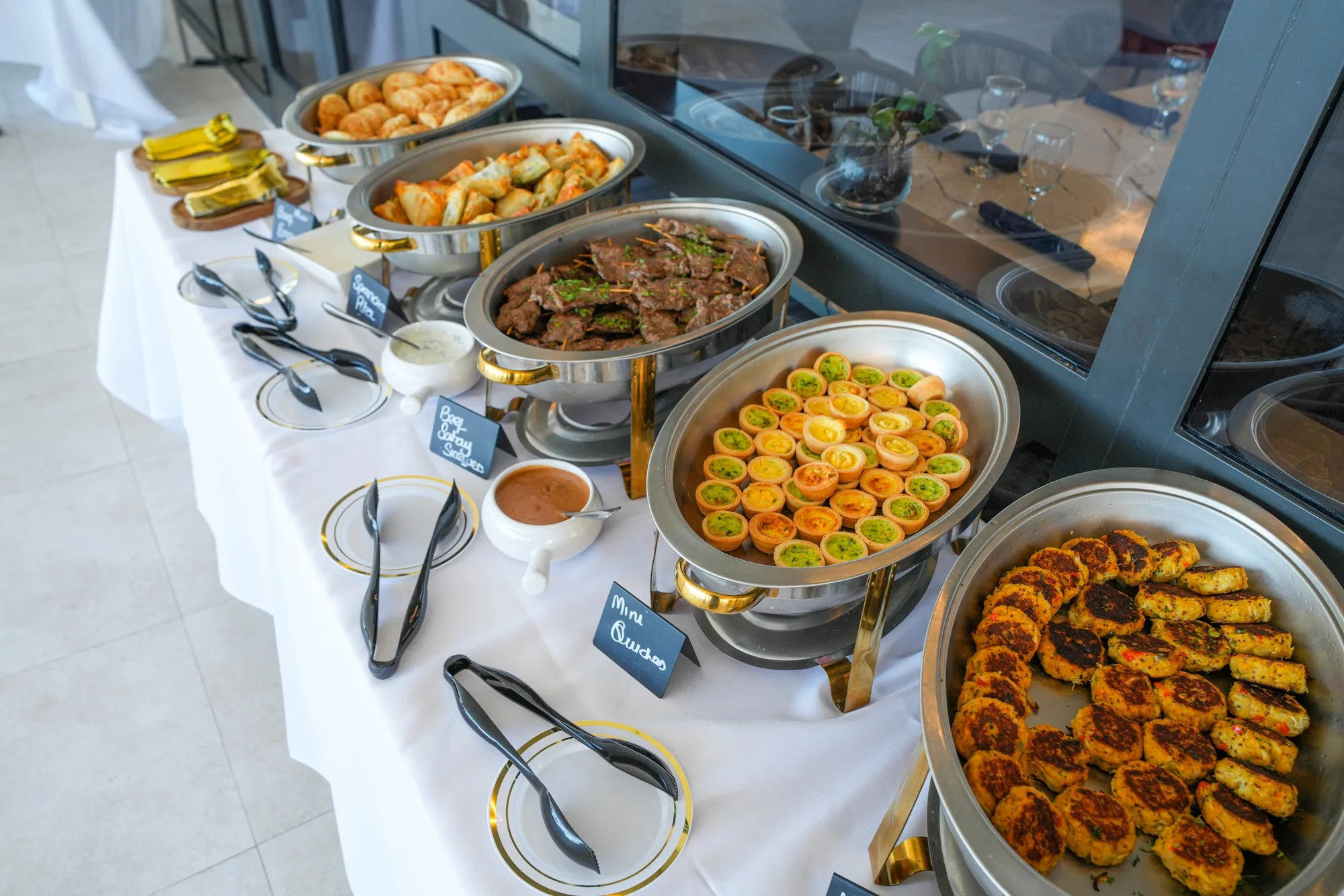 Catered buffet line with chafing dishes and appetizers ready for guests