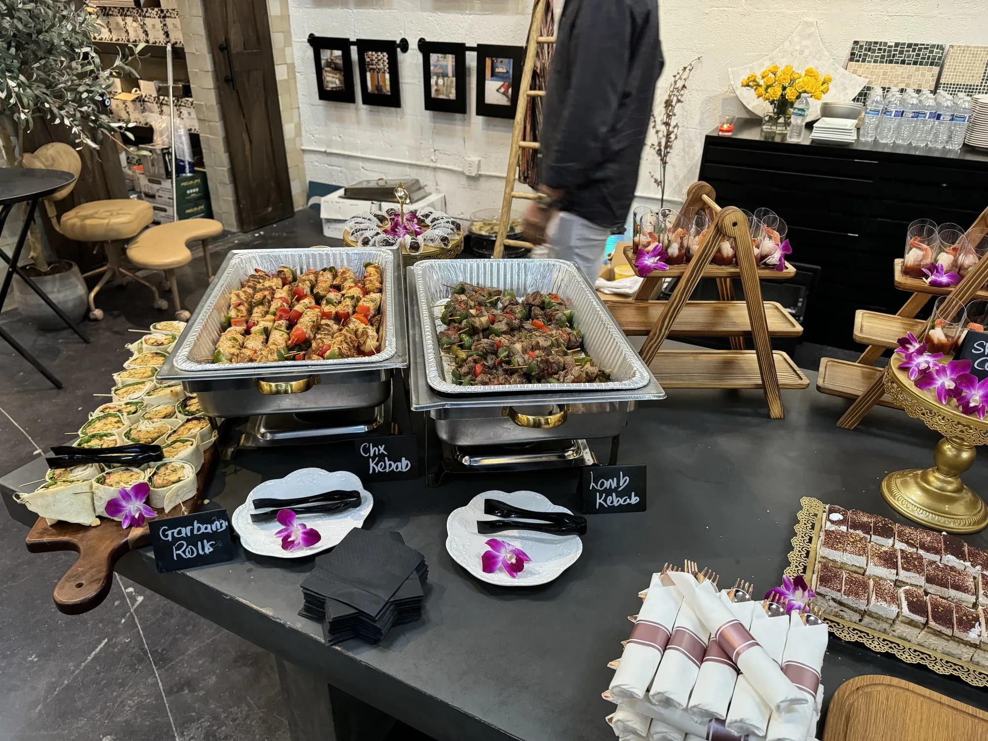 Buffet spread with appetizers and chafing dishes on black linen