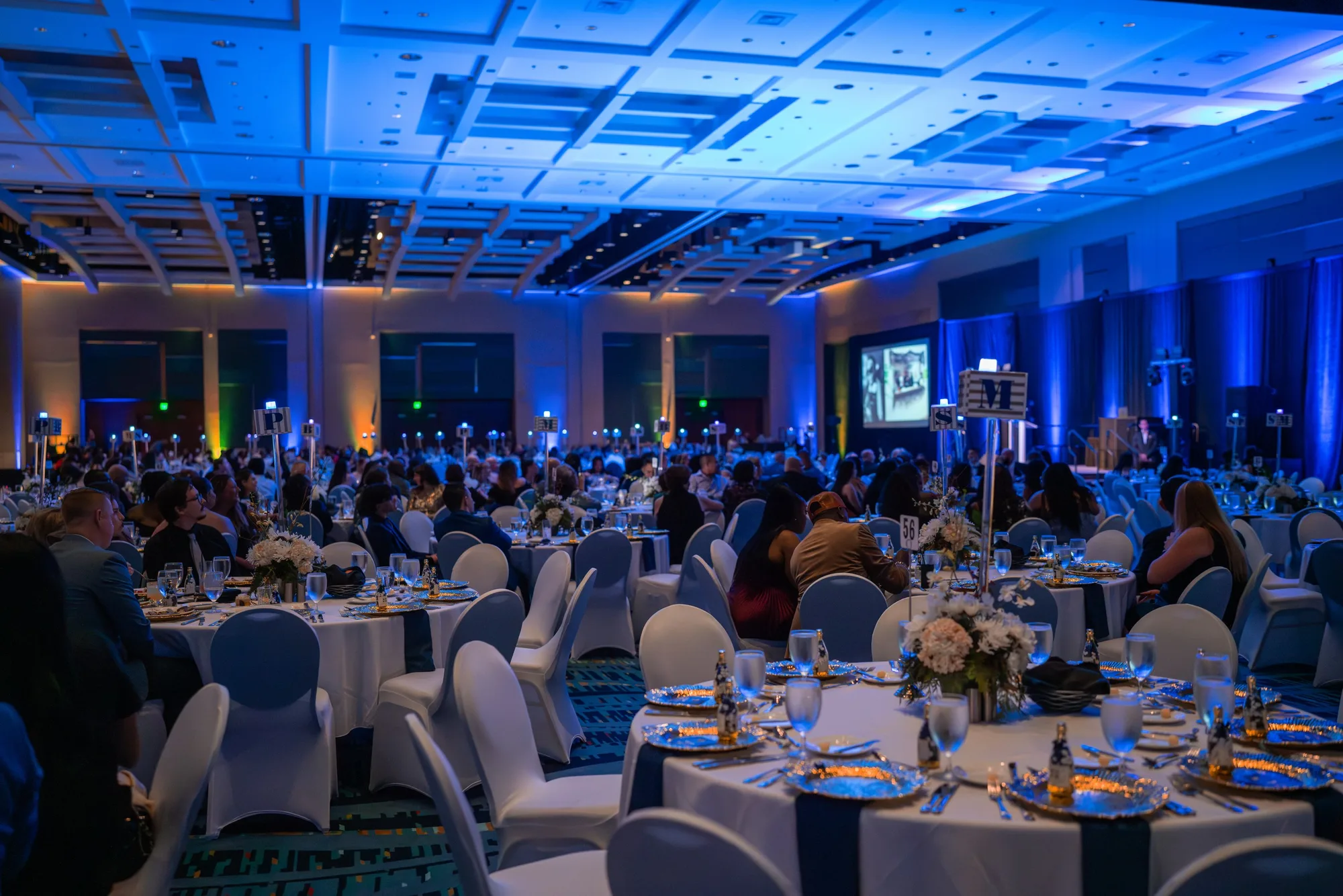 Wide view of a gala dinner in a hotel ballroom