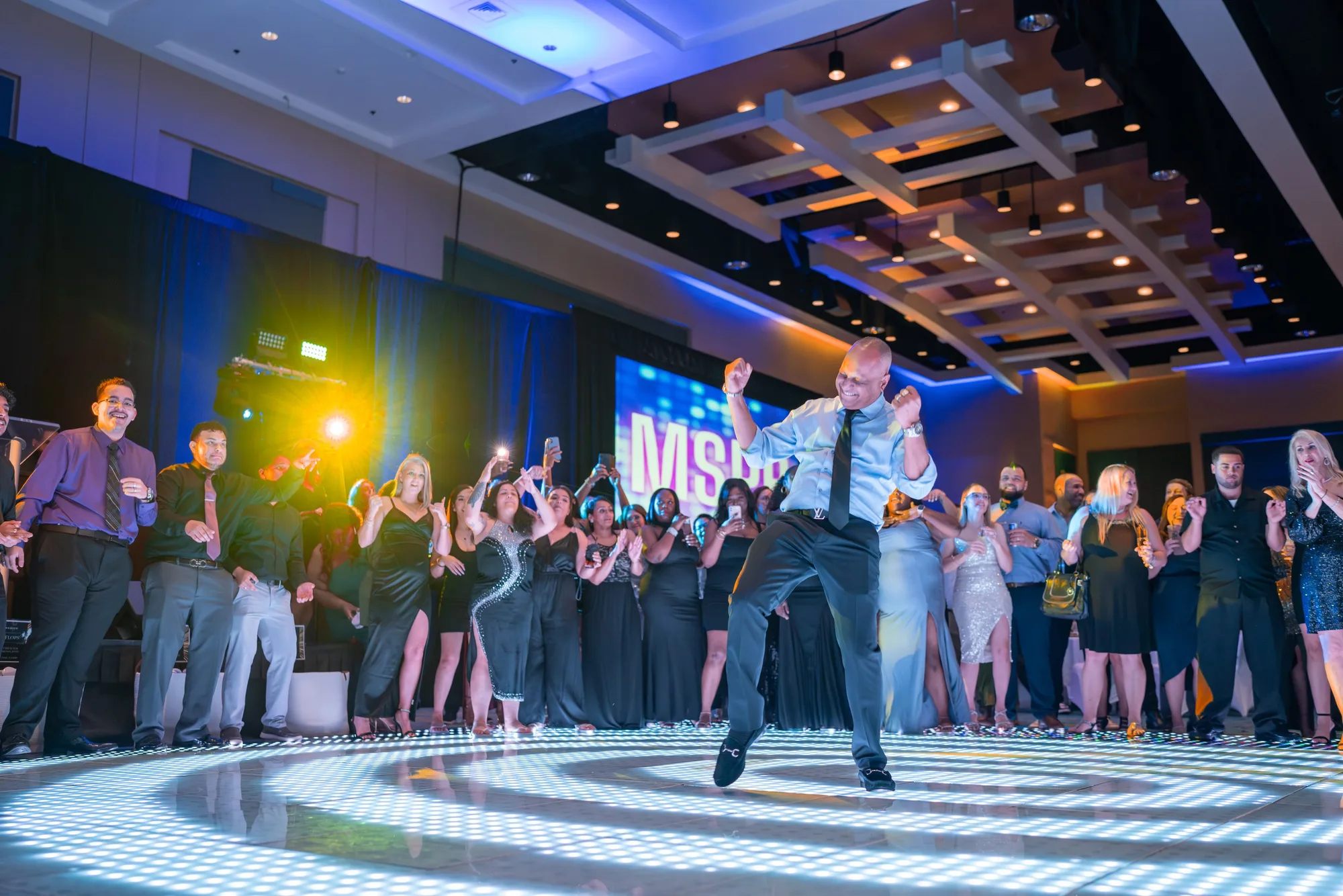 Gala guests dancing under stage lighting