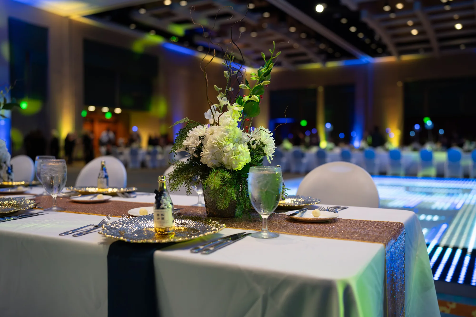 Gala table with floral centerpiece and uplighting