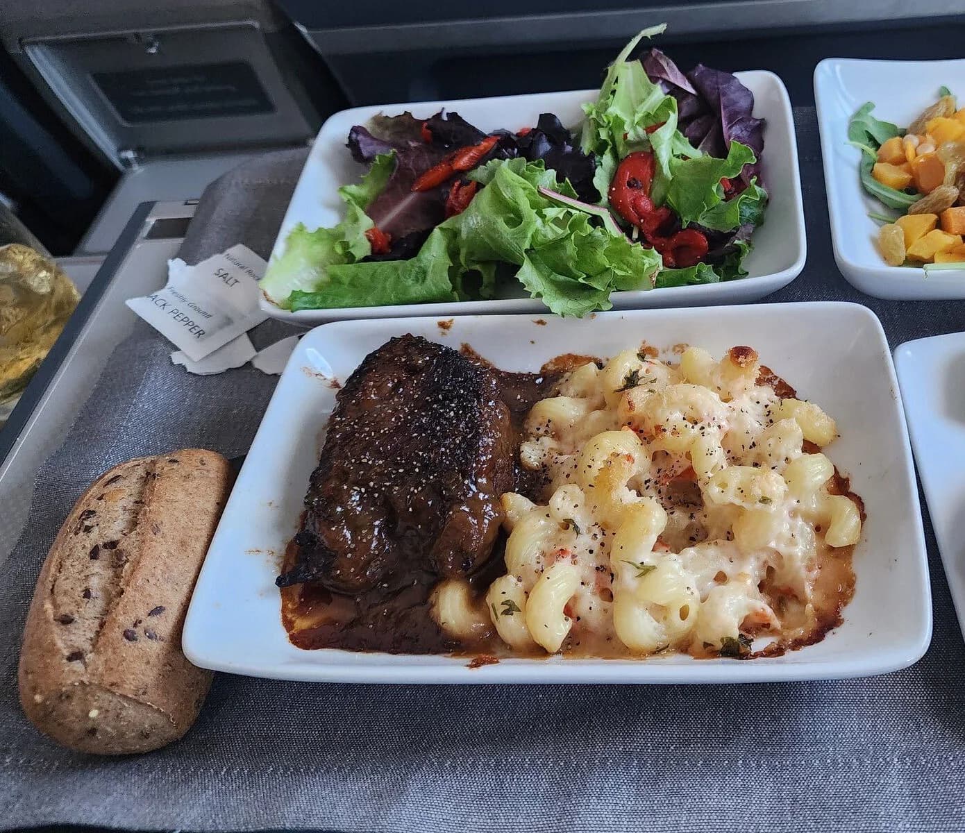 Tray set for the cabin: braised short rib with mac and cheese, mixed greens, bean salad and a roll