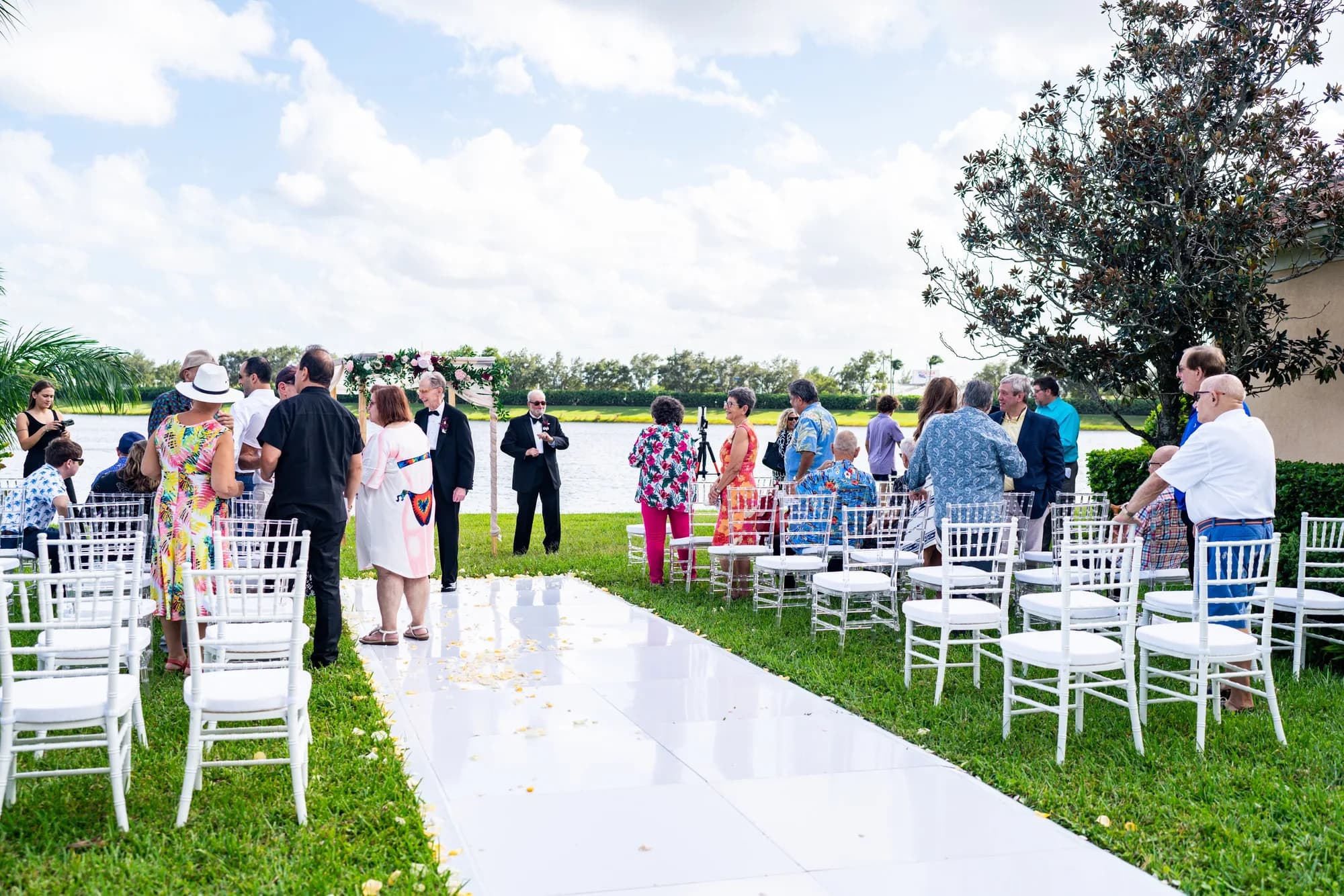 Lakeside wedding ceremony with white chairs