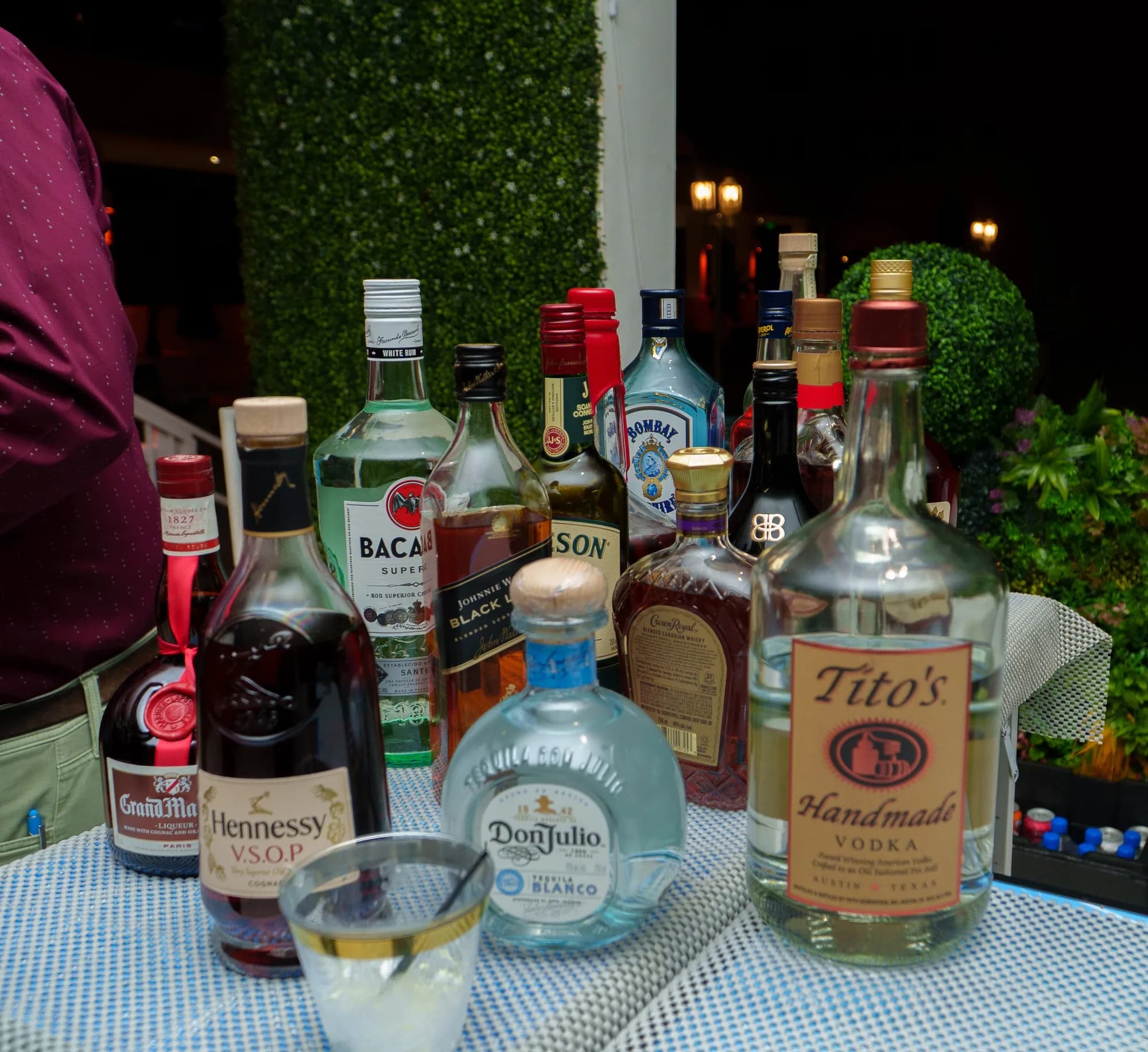 Premium spirits lined up on an outdoor bar at a catered party